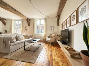 a living room with a couch and a tv at Cœur Cathédrale - Charme et vue fantastique in Chartres