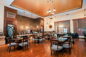 a dining room with tables and chairs in a restaurant at Bel-La Monde Hotel NH8 at 6km from IGI Airport Delhi in New Delhi