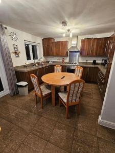 a kitchen with a wooden table and chairs in it at Relaxing Townhouse in Derby