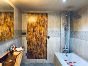 a bathroom with a tub and a wooden door at Sand Inn Residence in Kamadhoo +21 photos
