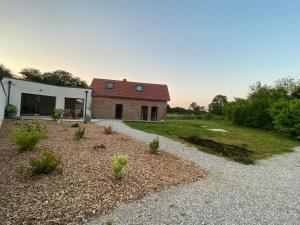 ein Haus mit einem Garten mit einer Kiesauffahrt in der Unterkunft A l oree du bois piscine intérieure privée sans vis à vis in Auvilliers