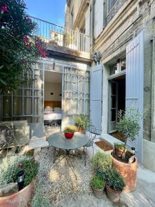 a patio with a table and some potted plants at Le Jardin des Etudes - Terrasse - Mansion 300 years in Avignon