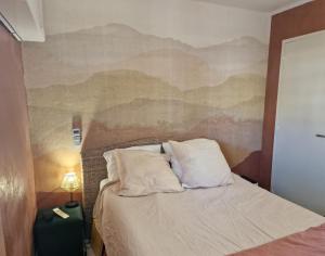sypialnia z łóżkiem i obrazem na ścianie w obiekcie Appt T3 VUE MER w mieście Six-Fours-les-Plages