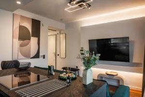 a living room with a table and a tv at Emerald Stone Apartment Varkiza in Vari