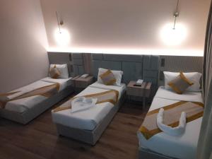 Habitación con 3 camas y 2 sofás en فندق رؤيا الاندلس النخبة - Roaya Alandalus Elite Hotel, en Medina