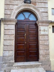 eine große Holztür in einem Steingebäude in der Unterkunft B&B Portaterra in Racale