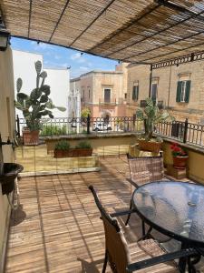 eine Terrasse mit Tisch und Stühlen auf einem Balkon in der Unterkunft B&B Portaterra in Racale