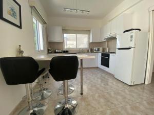 a kitchen with a white refrigerator and two bar stools at Polis Chrysochous Entire Apartment in Polis Chrysochous +5 photos