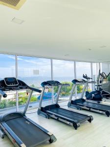 a gym with three treadmills in front of a window at Sweetie's room & The Blu x Bangsaen in Ban Bang Saen (1)