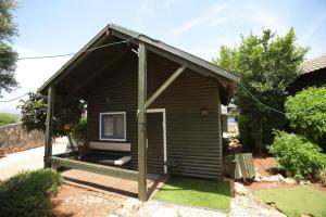 a small brown house with a porch and a porch at אגם ריזורט בטבע in Kallanit
