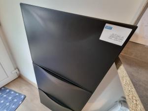 a black refrigerator in a kitchen with a sticker on it at Appartement "L'orée des trois frontières" in Allondrelle-la-Malmaison