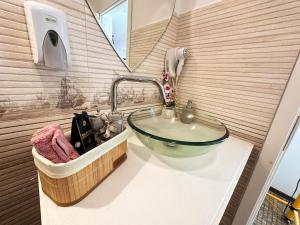 a bathroom with a glass sink and a mirror at Vitamine Central Apartment in Craiova +25 photos