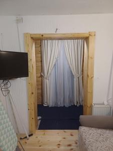 a room with a door with curtains and a television at Apartments Igor in Žabljak