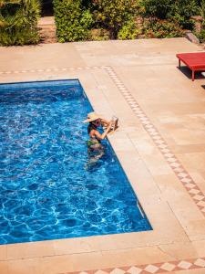 a woman wearing a hat in a swimming pool at Domaine de l'Astragale in Saint-Tropez