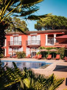 a large red building with chairs and a swimming pool at Domaine de l'Astragale in Saint-Tropez