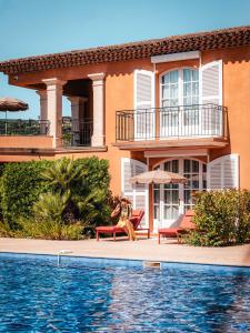 a man sitting on a bench in front of a house at Domaine de l'Astragale in Saint-Tropez