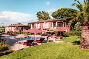a house with a swimming pool with chairs and umbrellas at Domaine de l'Astragale in Saint-Tropez