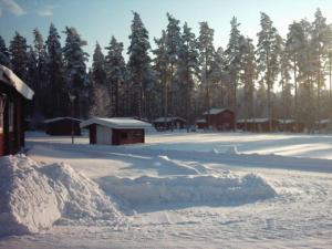 una pila de nieve junto a un edificio con árboles en Mullsjö Camping en Mullsjö