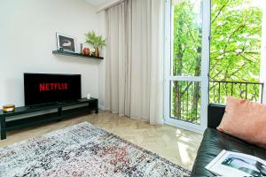 Una sala de estar con un sofá y un televisor. en Koszykowa 3 - Better Rental, en Varsovia