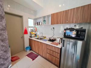 a kitchen with a stainless steel refrigerator with a microwave at SweetHome Brinchang Pent House - Pasar Malam area in Brinchang +28 photos