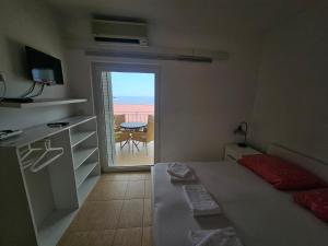 a bedroom with a bed and a view of a patio at Guest house Silvija - sea view in Primošten