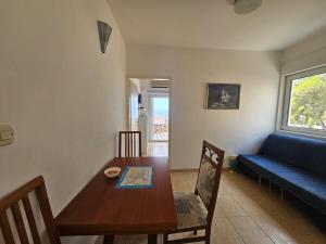 a living room with a table and a blue couch at Guest house Silvija - sea view in Primošten