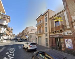 a city street with cars parked on the street at L'Alloggio dell'Artista in Belpasso