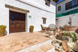 a patio with chairs and a wooden door at Casa Rural La Casa de la Abuela in Méntrida