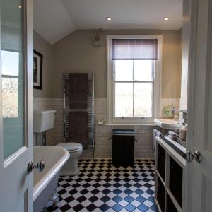 a bathroom with a tub and a toilet and a sink at Windsor Road Retreat in Richmond