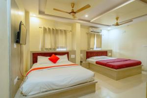 a bedroom with two beds and a flat screen tv at Majestic Hotel and Restro in Udaipur