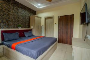 a bedroom with a bed and a television in it at Majestic Hotel and Restro in Udaipur