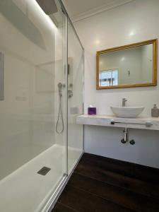 a bathroom with a glass shower and a sink at CLAREN´S BOUTIQUE ROOMS in Cangas del Narcea +25 photos