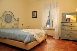 a bedroom with a bed and a dresser and a window at Oasi la Cascata in Le Marmore