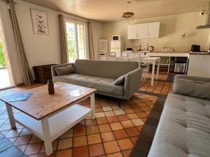 a living room with a couch and a table at La Millière - Piscine & campagne - Céleste in Le Poiré-sur-Vie