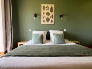a bedroom with a large bed with green walls at La Millière - Piscine & campagne - Céleste in Le Poiré-sur-Vie