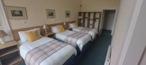 a room with three beds in a hotel room at Ashton Hall at Lancaster Golf Club in Lancaster