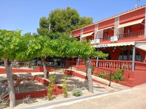 a red building with trees in front of it at Hotel Serra D'írta in Alcossebre