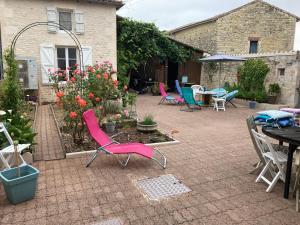 un patio con sedie, tavolo e fiori di Chambre chez l'habitant, Au moulin du Bonheur a Le Bourdet Altre 10 foto