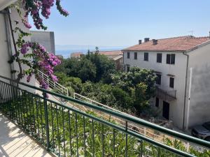 a balcony with a fence and purple flowers at Apartment Retro in Podgora