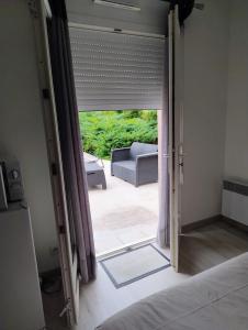 a bedroom with a door open to a patio at Chez Paul et Mélusine in Périgueux