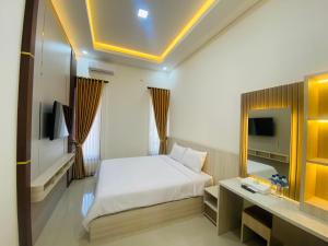 a hotel room with a bed and a mirror at Kanggo Riko Family Homestay Mitra Reddoorz in Banyuwangi +10 photos