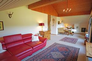 ein Wohnzimmer mit einem roten Sofa und einem Tisch in der Unterkunft Villa Schwarzwaldblick in Seelbach