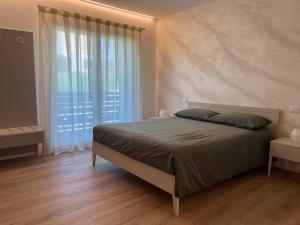 a bedroom with a bed and a large window at Alle Colline in Valdobbiadene