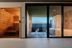 a bathroom with a view of a mountain through glass at Mt Fuji View and Private Sauna Ryokan Shizuku in Yamanakako