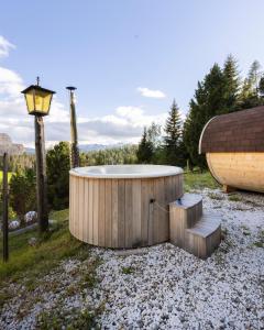 a bath tub sitting next to a boat on gravel at Bio Alpine Hotel Gran Fodà in San Vigilio Di Marebbe