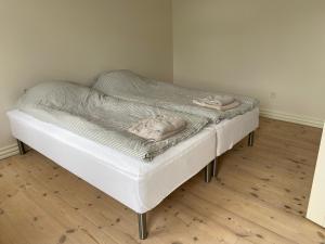 a white bed with two towels on top of it at Strømpehuset in Øster Assels