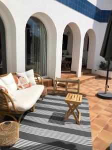 a patio with wicker chairs and tables on a rug at Charming Villa Son Parc in Son Parc