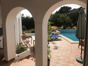 a patio with a swimming pool and two arches at Charming Villa Son Parc in Son Parc