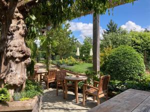 a patio with tables and chairs in a garden at The Brisley Bell in Brisley