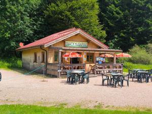 a restaurant with tables and chairs and umbrellas at la bulle des sapins in La Bresse